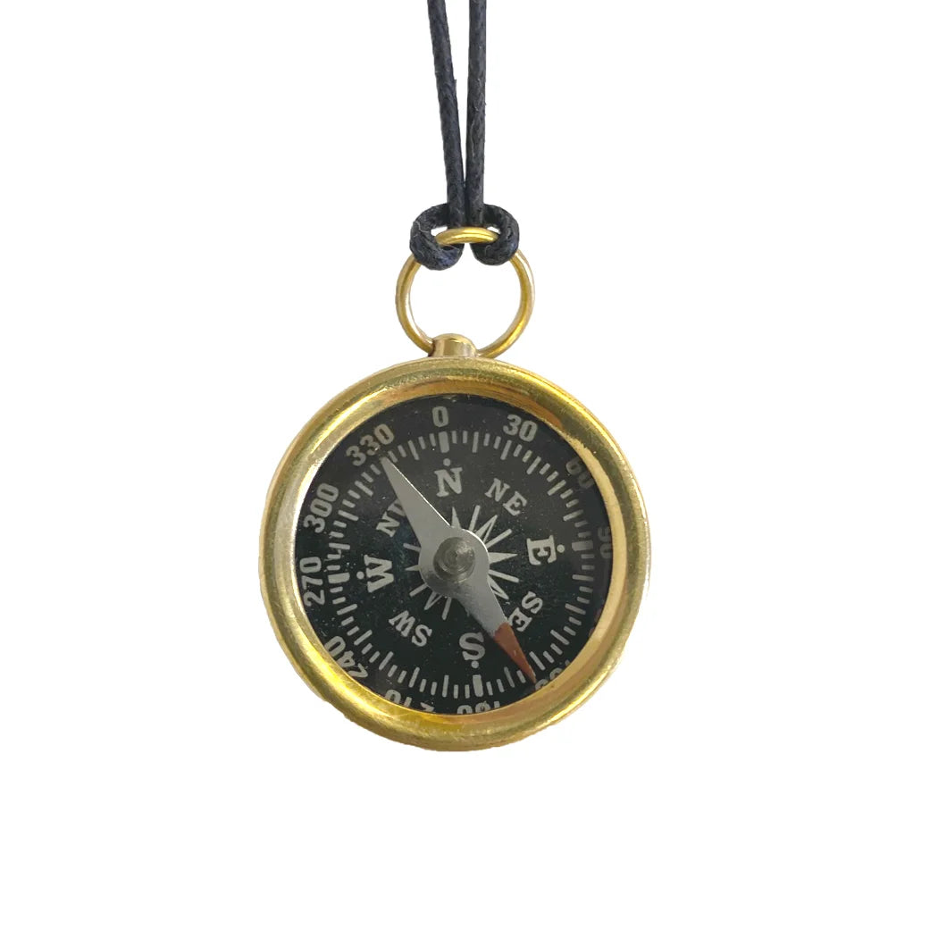 Compass pendant on a black cord against a white background