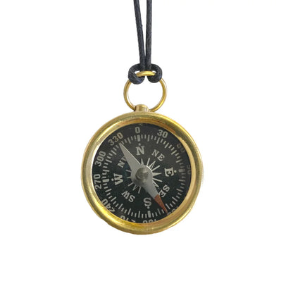 Compass pendant on a black cord against a white background