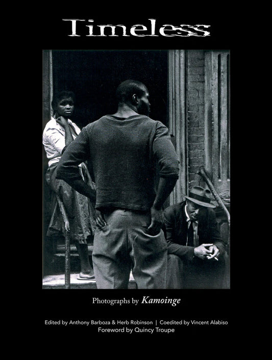 Book title: Timeless. The cover features a minimalist black‑and‑white photograph of a woman and two men at the entrance of a New York building stoop. The book’s title appears blurred and above the image.