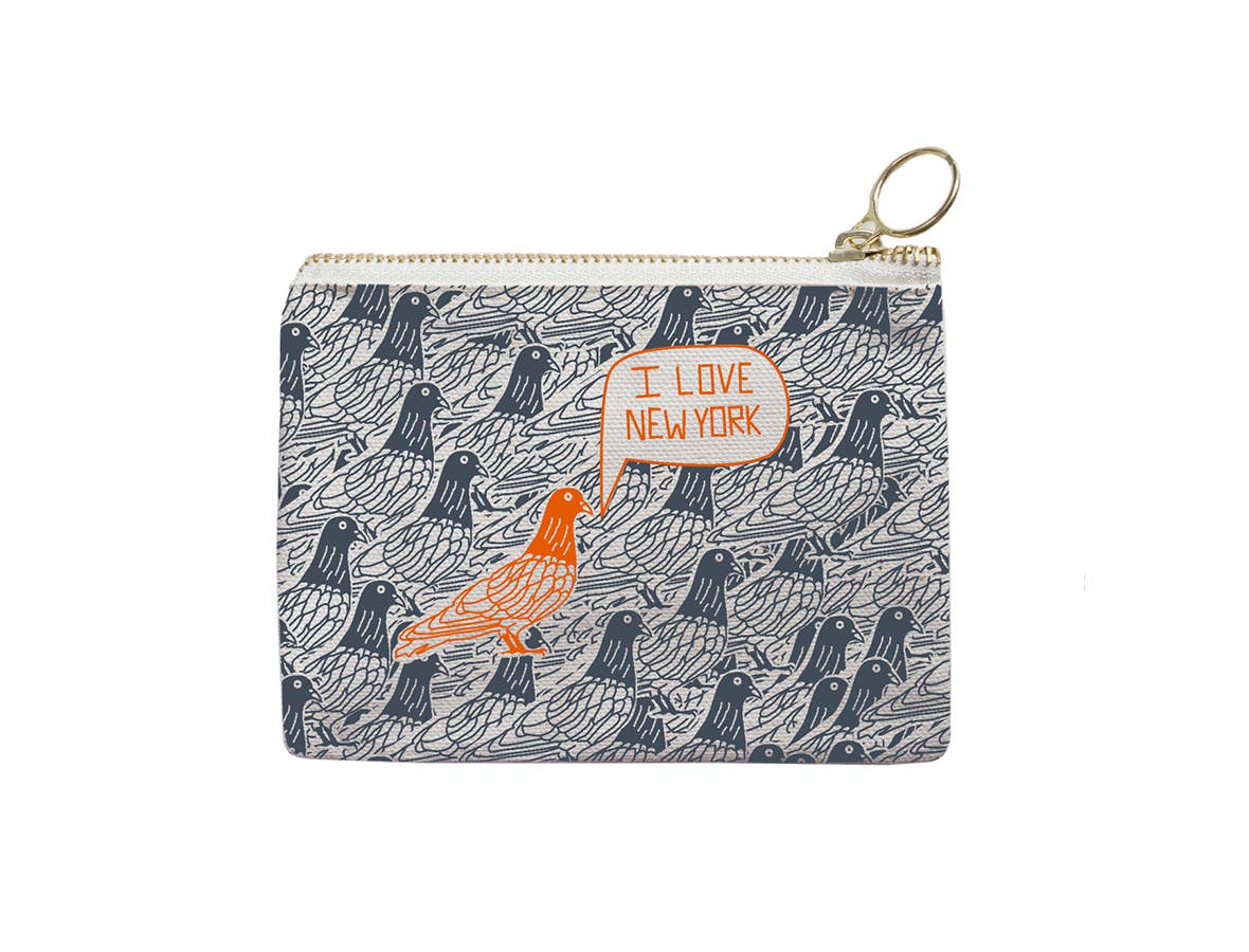 The item is a coin purse featuring a gold‑colored metal zipper with a round pull loop. The fabric is printed with a repeating pattern of grey pigeons drawn in a simple line‑art style. At the center, there is an orange‑outlined speech bubble containing the thin orange text “I love New York.” Directly beneath the text is a bright orange line‑drawing of a pigeon.