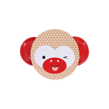 Product title: Miniature Wooden Tambourine -The design on the reverse side is printed with eco‑friendly, vegetable‑based inks directly onto the light natural wood, creating a clear winking monkey face set against a white polka‑dot background. Bright red metal jingles sit on each side like playful ears, their shine contrasting with the warm wood tones at the center.
