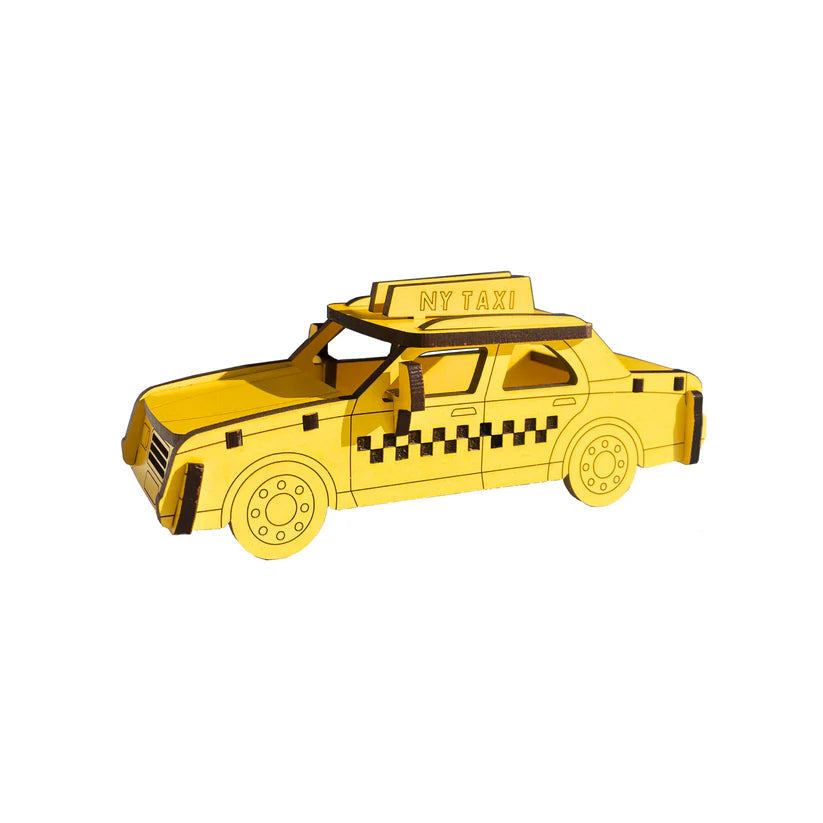 Product title: Iconic NYC Yellow Taxi 3D Wood Model. The image shows a small wooden model painted in bright yellow with black details, shaped like a classic New York City checker cab. The body is simple and rectangular with clean cut‑out features, and a small “New York Taxi” sign sits on the roof in a black outline with yellow lettering. The smooth wood surface and bold colors make the miniature instantly recognizable as an iconic NYC taxi.