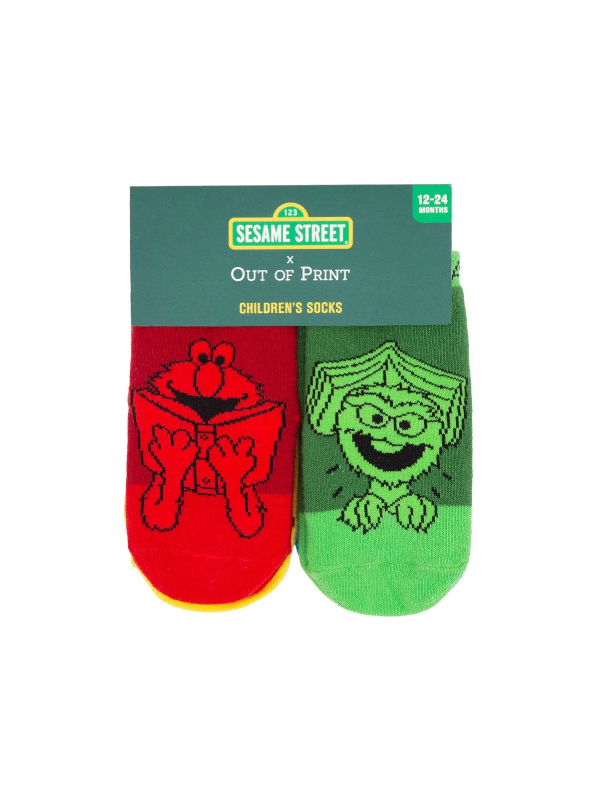 The image shows a Sesame Street–themed card holding a pair of toddler socks for ages 12–24 months. One sock is bright red featuring Elmo, and the other is bright green featuring Oscar the Grouch. The socks are attached side by side on the card, displaying both characters prominently.
