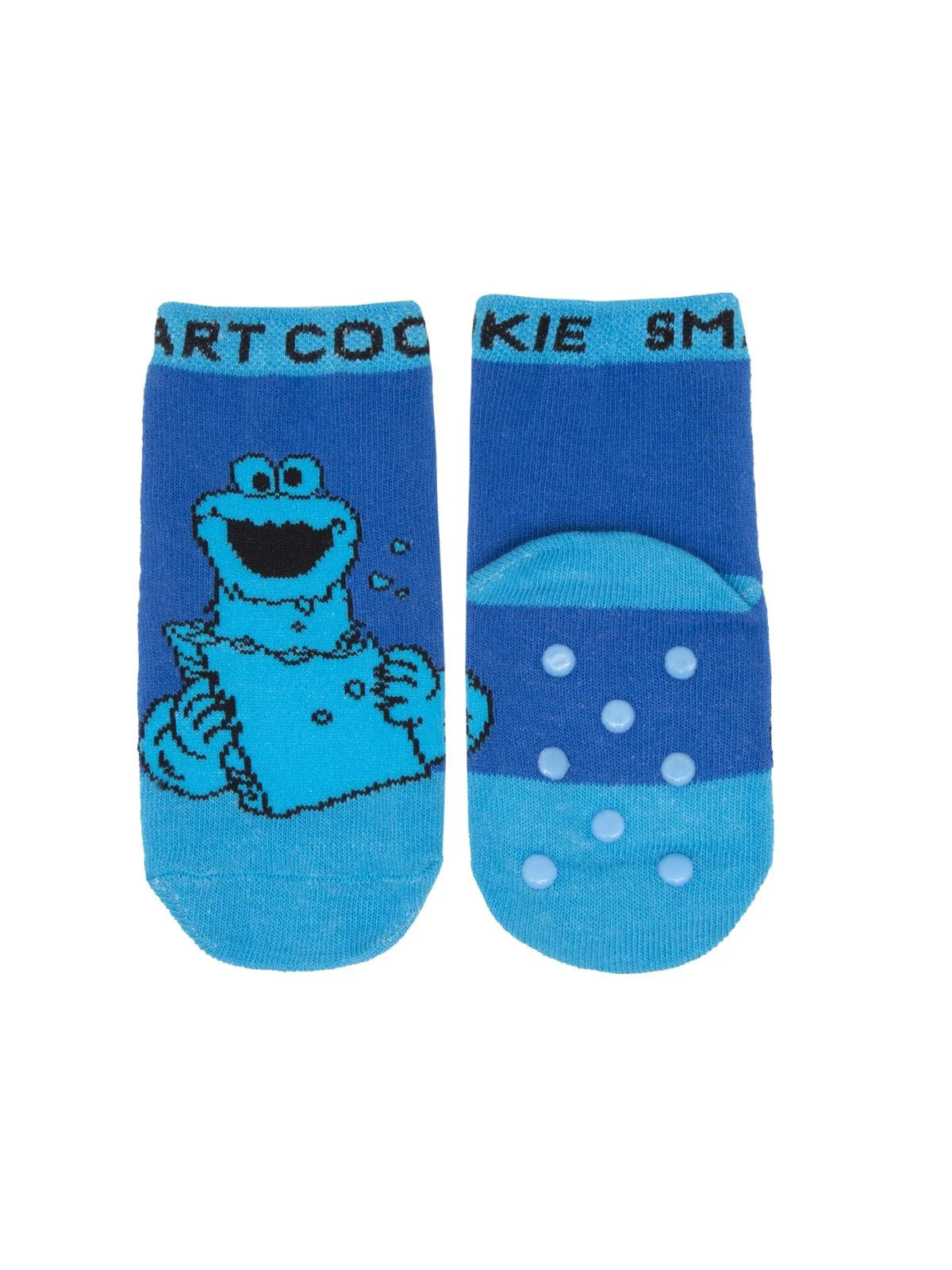 A photograph of bright blue toddler socks featuring a graphic image of Cookie Monster. The other sock is shown from the bottom, displaying rubberized anti‑slip dots across the sole..