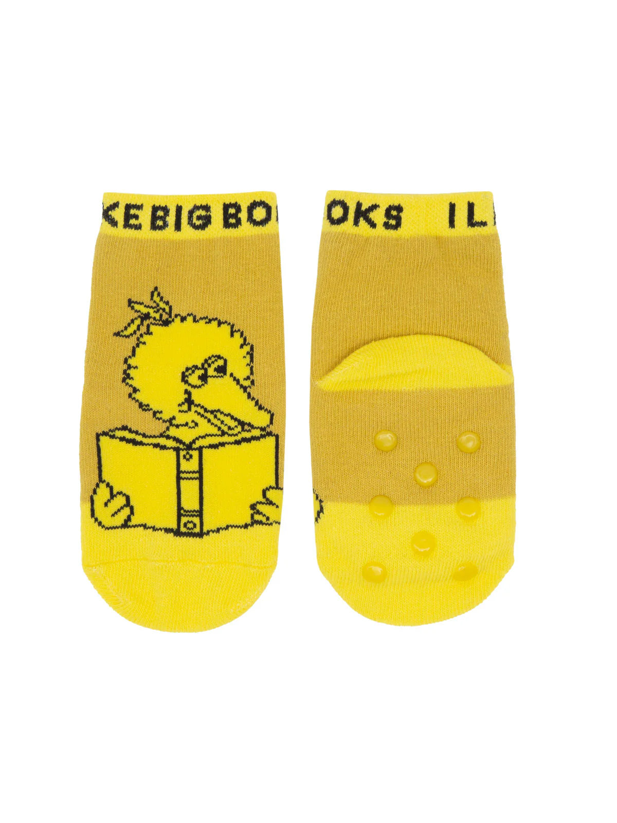 A photograph of toddler socks featuring Big Bird. The socks display a simple line‑drawing of Big Bird set against bright yellow background. The other sock is shown from the bottom, displaying rubberized anti‑slip dots across the sole.