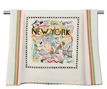 A white dish towel with a red, yellow and green stripe down each side, and hand dyed red, yellow and green rickrack at the top and bottom, printed with "NEW YORK" in black lettering surrounded by neighborhoods or locations spelled out with accompanying images. Includes places such as SoHo, Madison Square Garden, Times Square and the Guggenheim, among others, all embroidered in a variety of bright colors. 