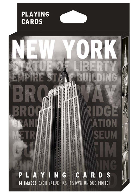New York Black & White Playing Card Pack: The image shows the packaging for a high‑contrast black‑and‑white deck. The front displays a bold photograph of the Empire State Building with “NEW YORK” in large white capital letters at the top and faint grey landmark names beneath. “Playing Cards” appears in white at both the top and bottom. The side panels feature additional black‑and‑white images of iconic New York buildings.