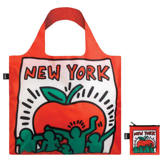 The bright red tote features a square panel on a white background, outlined in Keith Haring’s bold black lines. The front shows a vivid red apple with bright green dancing figures superimposed across the bottom, conveying rhythm and motion, while the back features a playful Statue of Liberty with radiant lines from her torch. Made from lightweight, water‑resistant recycled polyester, the bag feels smooth, crisp, and durable—and when not in use, it folds and zips into a compact square.