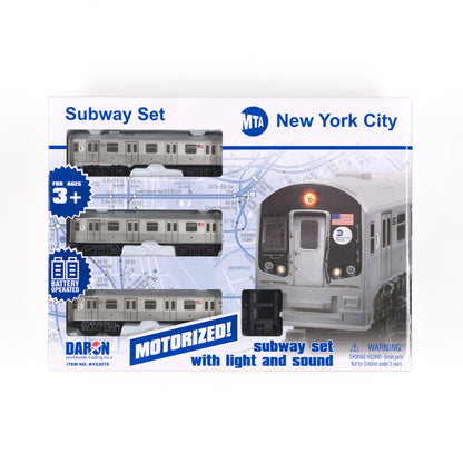 A rectangular box displays three gray subway models with black wheels set against a background of light‑blue graphics of the NYC subway map. The top panel features the MTA logo, with “New York City” printed in the upper‑right corner.