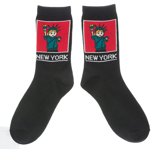 NYC Cartoon Statue of Liberty Socks 
These black crew socks feature a soft, woven cartoon image of the Statue of Liberty. On the ankle is a square red panel outlined in white, containing a friendly green Lady Liberty with small orange details in her hair and torch flame. Below the panel, “NEW YORK” appears in large, bold lettering in white. The socks feel smooth and flexible, made for comfortable everyday wear with playful New York character.