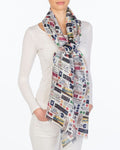 A white scarf with train symbols in various colors. Symbols include: metro card, light rail, subway signs, etc.