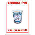 A light blue coffee cup with the words New York in a white emblem. The pin is on a white backing with a red striped border.